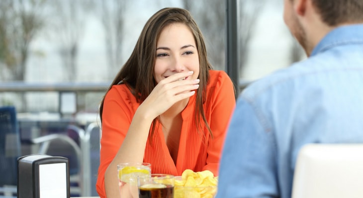 Woman laughing while covering her smile