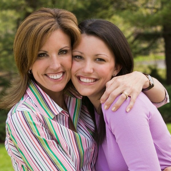 Mother and daughter outdoors smiling
