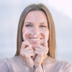 Woman holding clear aligners in the shape of a heart